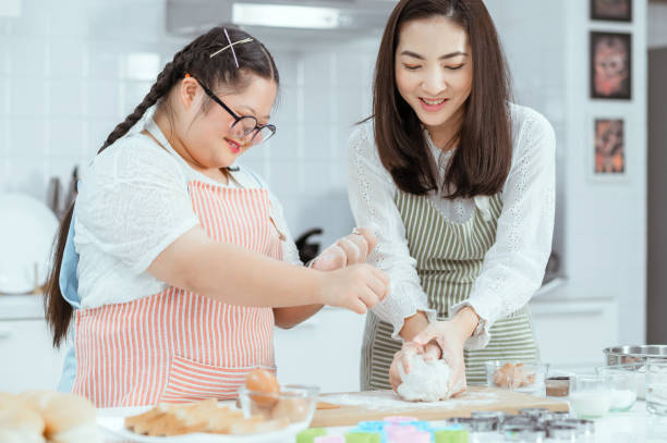 istock Young Downs Syndrome Couple Baking In Kitchen At Home 1351271726