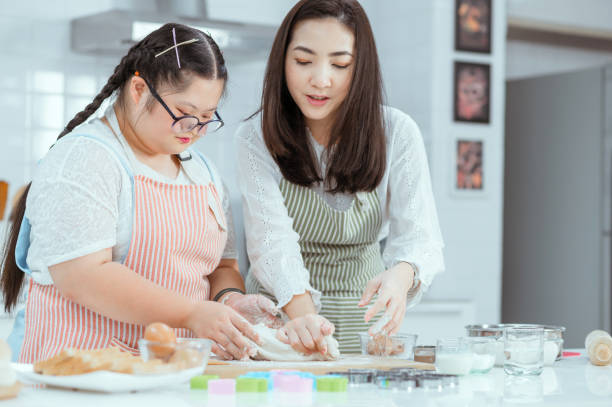 istock Young Downs Syndrome Couple Baking In Kitchen At Home 1351271731