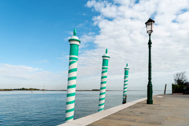 Three turquoise striped poles in Burano (Venice, Italy) on a sunny day in Autumn