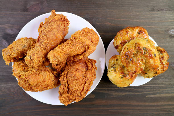 istock Plate of Mouthwatering Crispy Fried Chickens with Aromatic Herb Biscuits on Wooden Backdrop 1351273541