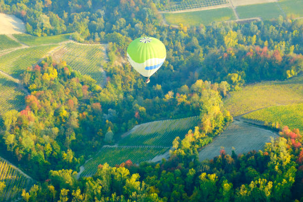 Hot air balloon flying over Langhe vineyards. Color image stock photo