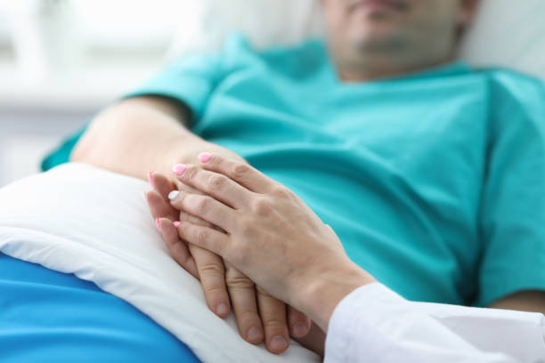 istock Doctors hands hold hands patient lying in ward 1351274090