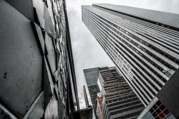 Skyscrapers seen from a low angle view rising directly to the sky in New York's financial district named Manhattan representing powerful and modern architecture.