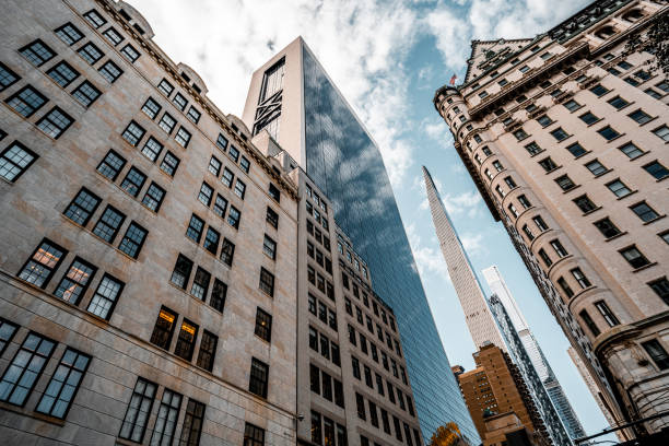 Low angle view at tall corporate buildings that makes you feel like you can touch the sky  seen directly from below during one sunny autumn day in Manhattan, New York.