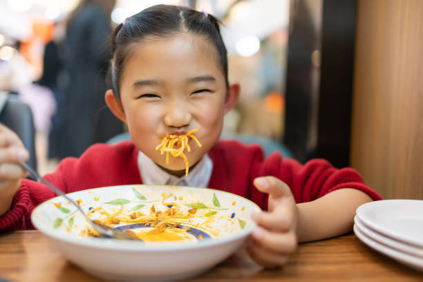 istock Little girl eating spaghetti 1351274820