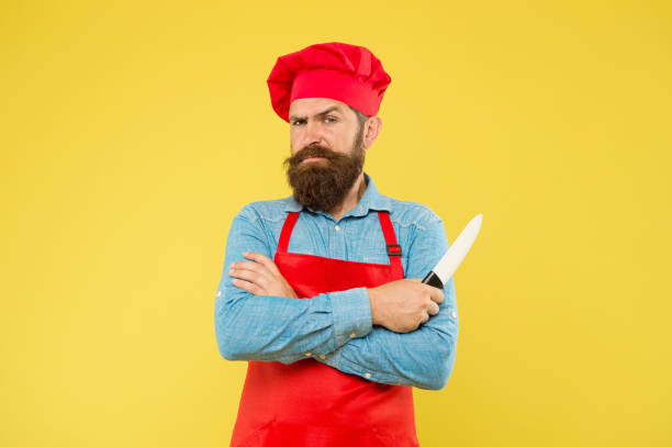 istock Chef handsome bearded cook in red uniform hold sharp professional knife 1351276887