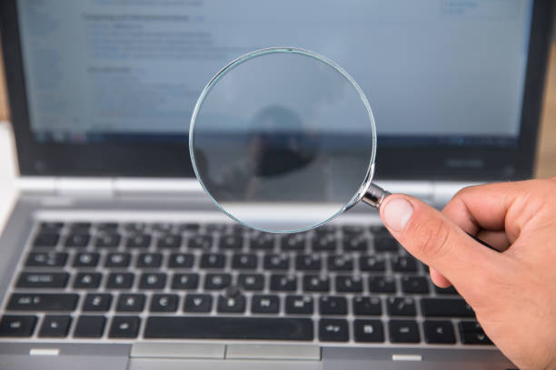 istock man holding magnifier with laptop 1351278350