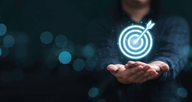 istock Virtual target board on hand with blue bokeh background for set up business objective target concept. 1351278408
