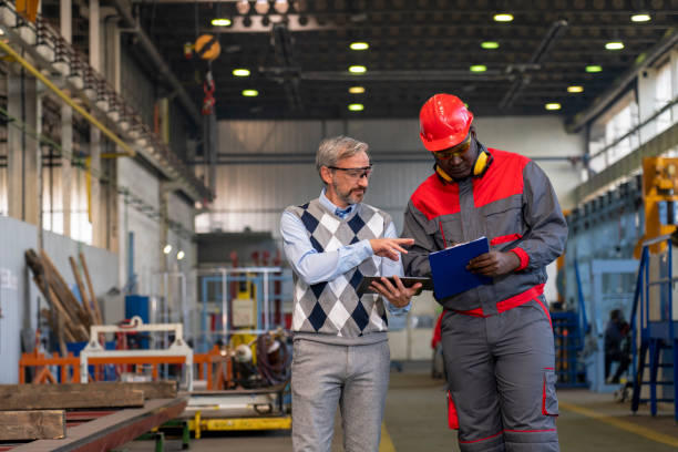 istock Caucasian Manager Giving Orders To Black Worker in Protective Workwear With Clipboard 1351279749