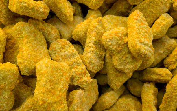 istock Stack of frozen raw chicken nugget on market display 1351280914