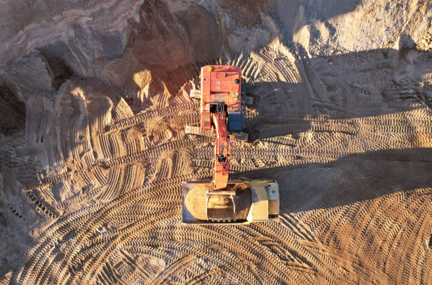 istock Mining excavator load the sand into dump truck in open pit. Developing the sand in the opencast. 1351280978
