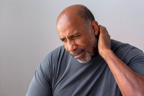 Portrait of an older senior man having pain in his neck. stock photo