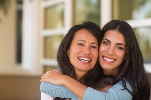 Mother and her adult daughter hugging and laughing stock photo