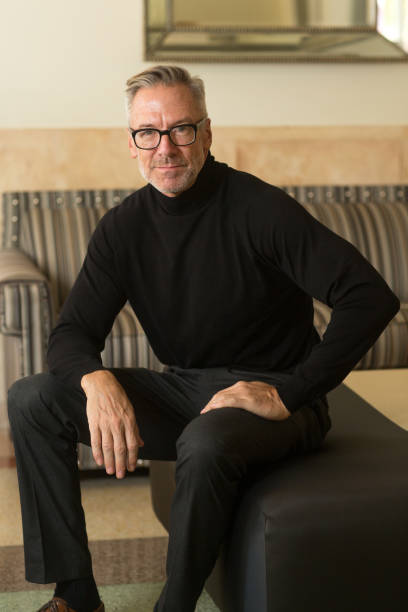 istock Portarit of a handsome older man sitting on a sofa 1351281744