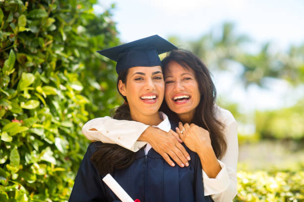 Mother hugging her daughter at her graduation stock photo