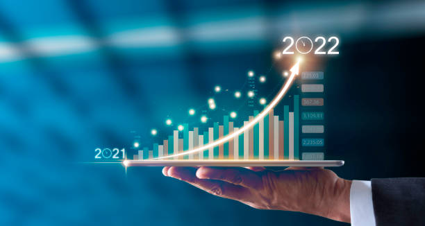 бизнесмен держит планшет в руке, показывающий график экономического роста, нацеленного на успех с 2021 по 2022 год. - market target стоковые фото и изображения