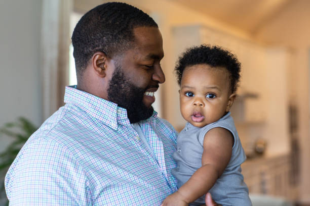 istock Loving father smiling and playing with his son at home. 1351284137