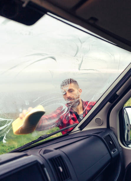 istock Man cleaning motorhome glass outdoor 1351284151
