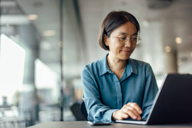 Hardworking adult asian woman, joining a conference call stock photo