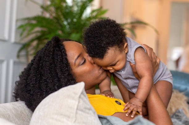 istock Happy mother smiling and playing with her son at home. 1351284343