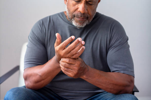 Portrait of an older senior man having pain in his hand. stock photo