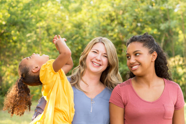 istock Happy mother and her two daughers laughing and smiling. 1351285535