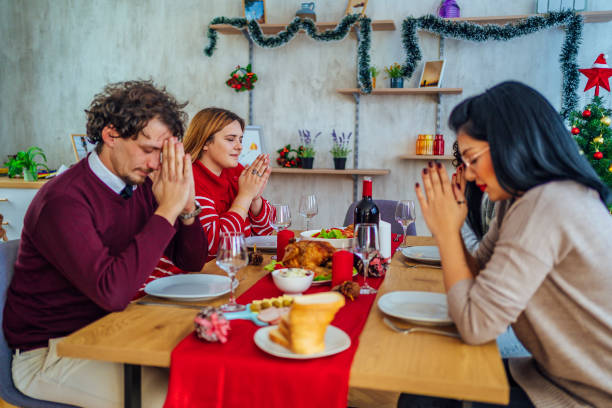 istock Friends praying at served table before holiday dinner 1351286396
