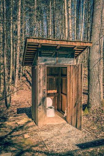 Backcountry outhouse in a wooded setting.