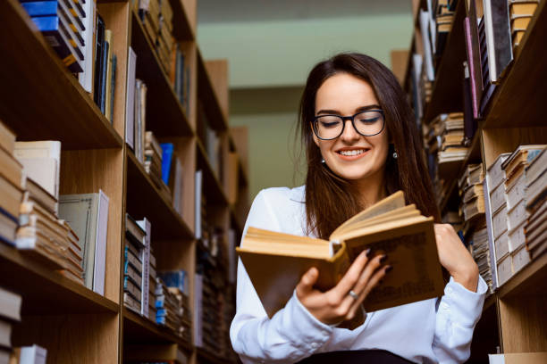 istock Attractive young brunette woman reading a book 1351287178