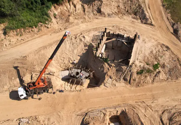 Photo of Сonstruction of storm sewer collector. Truck crane during the pouring of the formwork. Drainage Sewerage Storm Tunnel. Laying Sewer pipes.