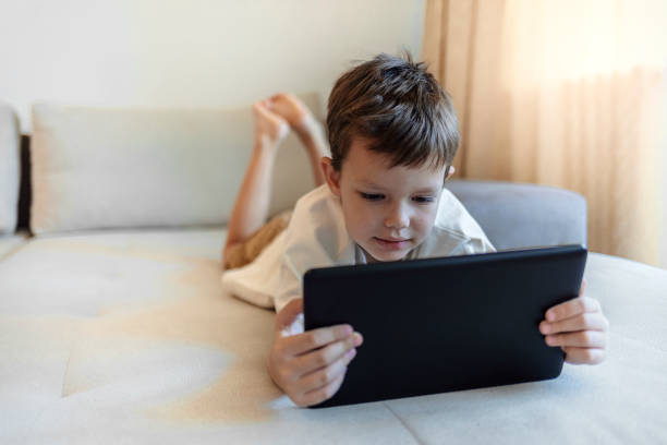 istock Small boy surfing the net on touchpad. 1351289772