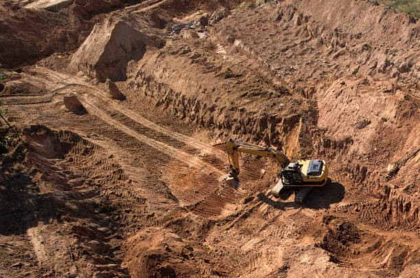 istock Excavator dig ground at a construction site. Trench for laying external sewer pipes. 1351289920