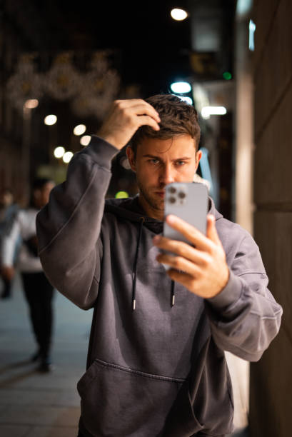 istock Man adjusting hair on street 1351289952