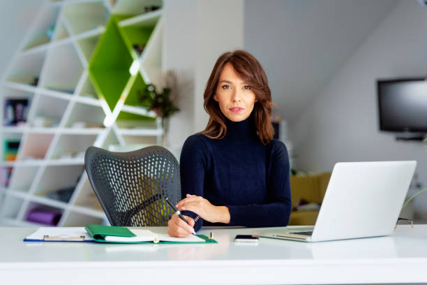 istock Attractive businesswoman using laptop while working at the office 1351290877