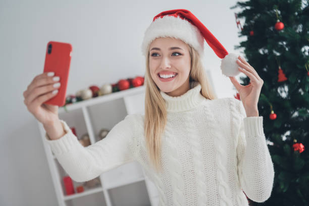 istock Photo of shiny cute young lady wear knitted pullover smiling tacking selfie modern device indoors house home room 1351291053