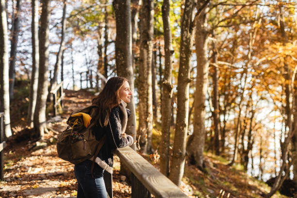 giovane donna escursionista che guarda la foresta autunnale - hiking adventure outdoor pursuit backpacker foto e immagini stock