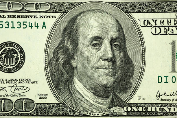 United States hundred dollars money bill closeup. Portrait of US president Benjamin Franklin on 100 dollars banknote macro fragment. stock photo