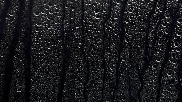 Rain drops on a black background. The background can be remove using a blending mode like screen. stock photo