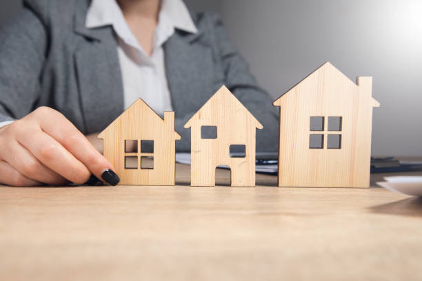 istock business woman holding house models 1351294579