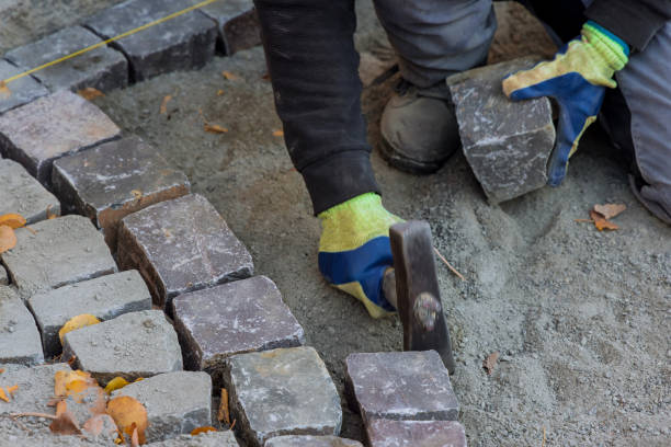 istock Paving worker using hammer pavement with granite stones cobblestones for paving road 1351297652
