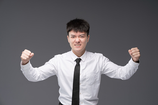 Young Asian white-collar workers, dressed in suits and ties, clenched their hands and looked excited