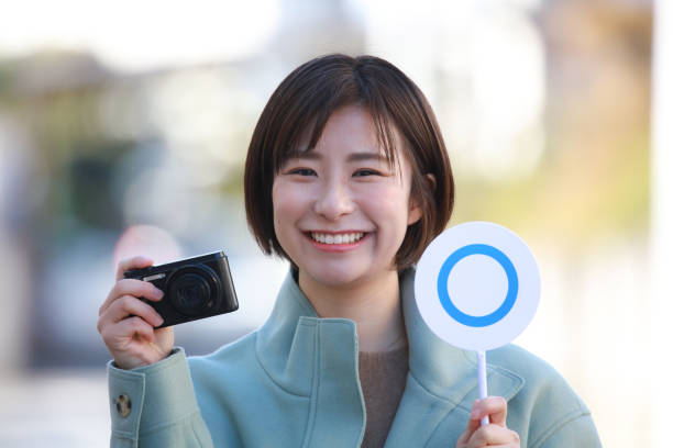 istock A woman with a compact digital camera and a 〇 tag 1351300468