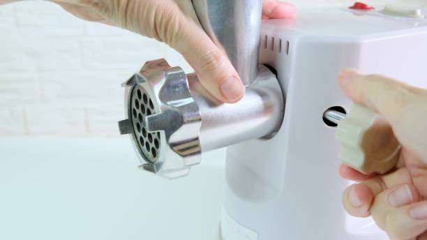 istock Woman hands assembling modern electric meat grinder, mincer for making minced meat 1351300845