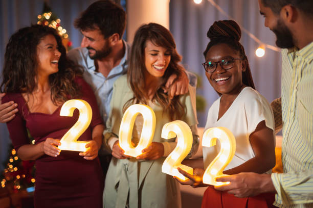 istock Friends holding illuminative numbers 2022 while celebrating New Year 1351301105