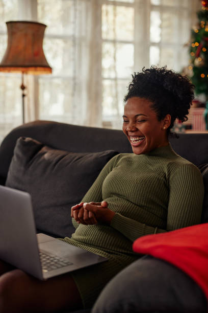 istock Black woman sitting on sofa and having video call 1351302667