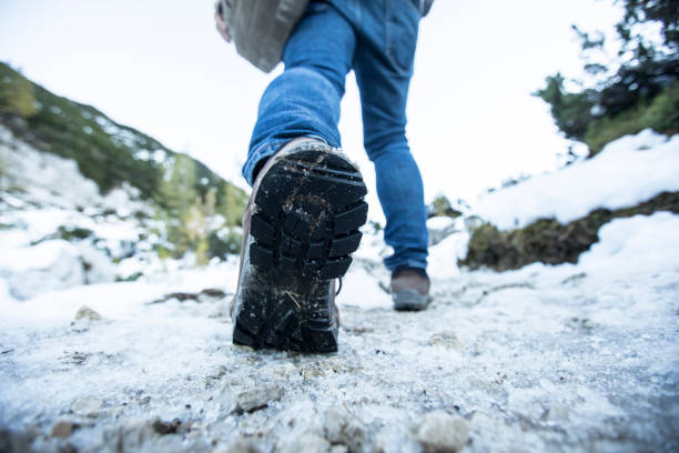 istock Low Angle View Close-up of Man in Hiking Boots on Snow 1351302934