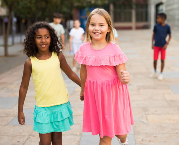 istock Two young girls walking hand in hand 1351305315