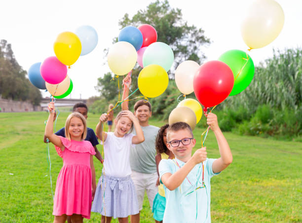 istock Barefoot kids playing with balloons on grass 1351305407
