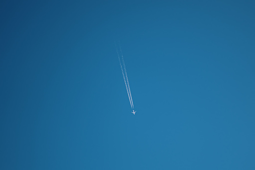 An airplane in the sky leaving a trail