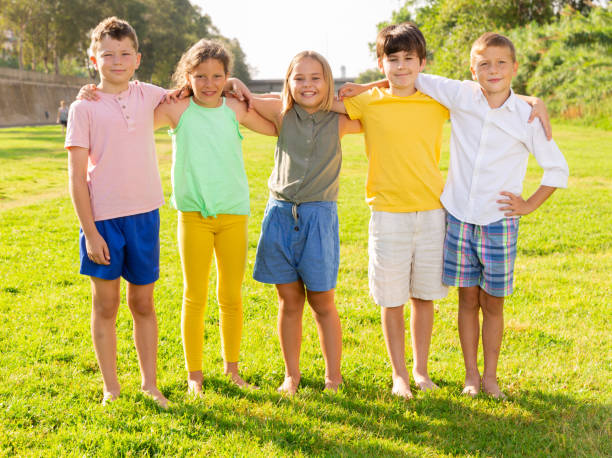 Portrait of five glad children who are walking and posing in park Portrait of five glad children who are walking and posing in the park child 10 11 years 8 9 years cheerful stock pictures, royalty-free photos & images